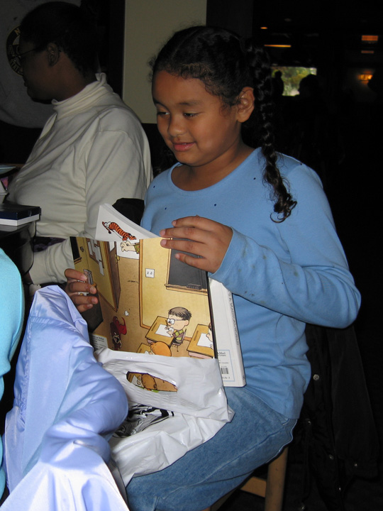 Daddy gives Mari a bunch of Calvin + Hobbes books!