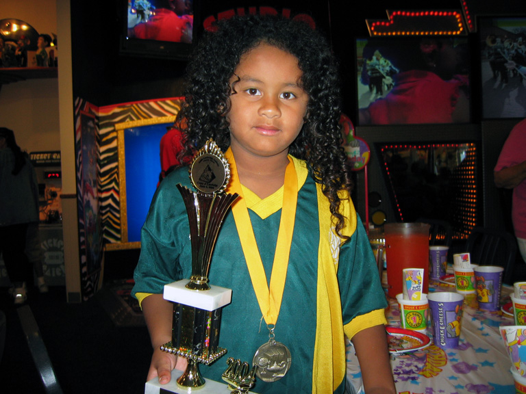 Mari wears her medal and trophy from taikwando!